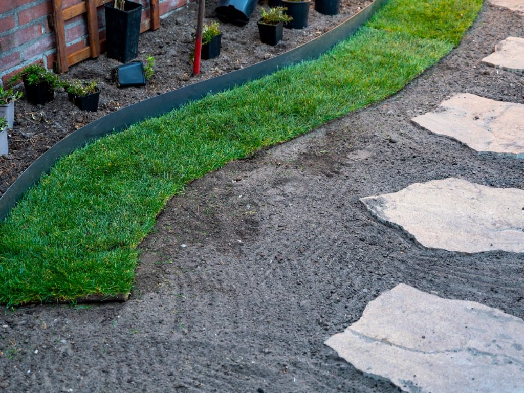 Making of natural green lawn in garden with rolls of green grass, garden renovation works in spring Lawn Installation Southington CT